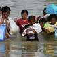 Residents wade through floodwaters as they return to their.... photo: 1646487 slideshow 31095