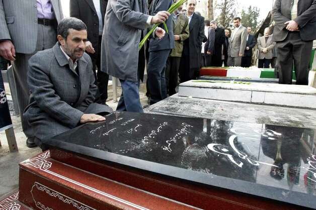 Iranian President Mahmoud Ahmadinejad prays at the grave of Gen