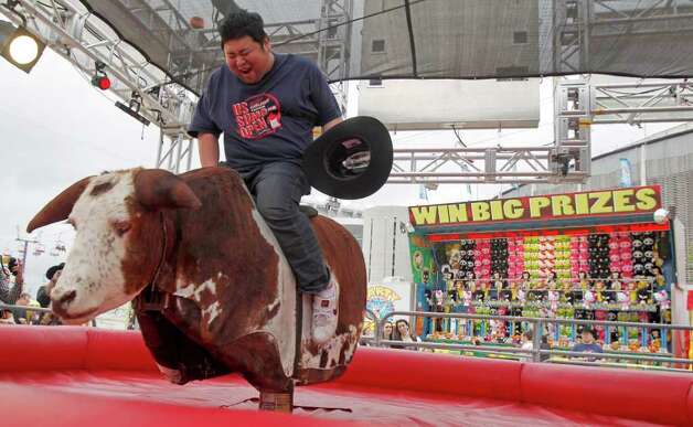 Japanese Sumo wrestler Takuji Noro who competes as "Noro" rides a mechanical bull during a tour of The Houston Livestock Show & Rodeo Wednesday, March 7, 2012, in Houston. Photo: James Nielsen, Chronicle / © 2011 Houston Chronicle