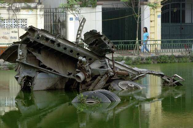 A woman walks near the wreckage of a B-52 in a small lake in Hanoi, Vietnam on Nov. 15, 2006. The bomber was  shot down in
 1972. Photo: SHAH MARAI, AFP/Getty Images / 2006 AFP