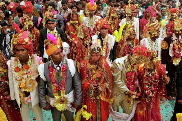Indian brides and grooms pose for photographs after marriage rituals during