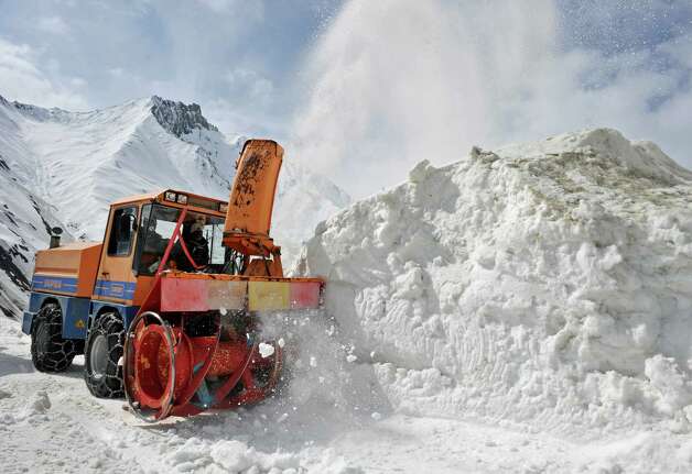 A snow clearing vehicle cuts through snowdrifts at the Srinagar-Leh highway in Zojila, about 67 miles east of Srinagar, on Wednesday. The 275-mile highway was opened for the season by Indian Army authorities after remaining snow at Zojila Pass, some 11,581 feet above sea level, had been cleared. The pass connects Kashmir with the Buddhist-dominated Ladakh region, a famous tourist destination among foreign tourists for its monasteries, landscapes and mountains. AFP PHOTO/Tauseef MUSTAFA Photo: TAUSEEF MUSTAFA, AFP/Getty Images / 2012 AFP