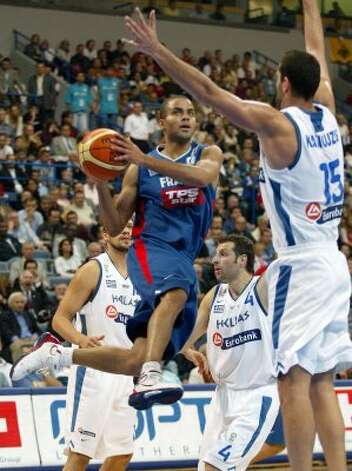 France's Tony Parker, center, who also plays for the San Antonio Spurs, goes for a basket between Greece's Michail Kakiouzis, right, and Theodoros Papaloukas, second from right, during their European basketball championship semi-final match in Belgrade, Serbia and Montenegro, September 24, 2005. (Marko Djurica / Reuters) / SA