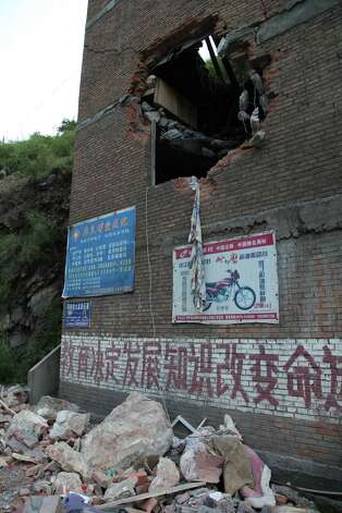 A damaged building in Yiliang, southwest China's Yunnan province on Friday after two shallow quakes that struck the remote and mountainous border area of Yunnan and Guizhou province of southwest China.   Dozens of people were killed and 550 injured when two shallow quakes with a magnitude of both at 5.6 struck a remote and mountainous area of southwest China, toppling buildings and sparking chaos in the streets, officials said.   ( AFP/AFP/GettyImages) Photo: AFP, Ap/getty / 2012 AFP