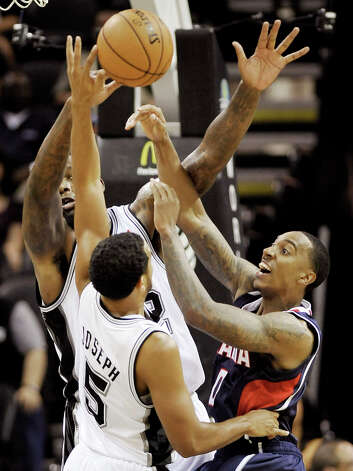 The Atlanta Hawks' Jeff Teague (right) is defended by the Spurs' Cory Joseph (5) and Eddy Curry during the first half Wednesday, Oct. 10, 2012, in San Antonio. Photo: Darren Abate, Associated Press / FR115 AP