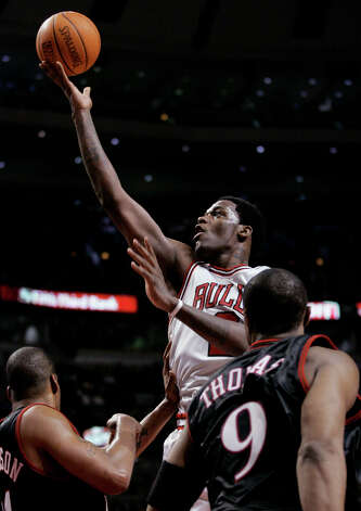 The Chicago Bulls' Eddy Curry (center) shoots over the Philadelphia 76ers' Corliss Williamson (left) and Kenny Thomas during the third quarter, Wednesday, Jan. 12, 2005, in Chicago. The Bulls won 110-78. (Brian Kersey / Associated Press) Photo: BRIAN KERSEY, AP / AP