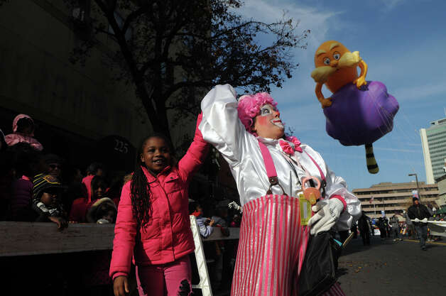 Sanaayh Dotson, 8, dances with a Cirque-tacular clown, played by Barbara Occhino, during the UBS Parade Spectacular in Stamford, Conn., Nov. 18, 2012. Photo: Keelin Daly / Stamford Advocate Freelance