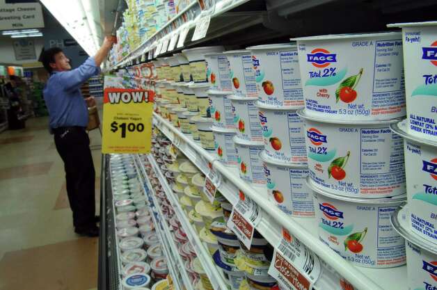 Hannaford store manager Ron Frasier adjusts a display of Greek yogurt, including FAGE Greek yogurt, made in Johnstown, NY, at the Hannaford store in Latham Farms on Thursday June 9, 2011 in Latham, NY.  ( Philip Kamrass / Times Union) Photo: Philip Kamrass / 00013490A