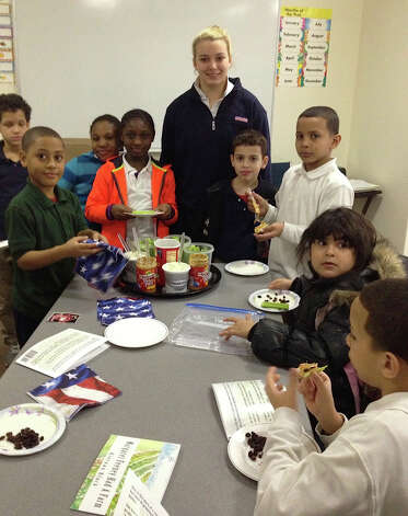 Girl Scout Kiernan Black gathers with students in one of her nutritious foods classes. For her community-service project to earn the Gold Scout Award, Black wrote a children's book about a woman who gathered fruits and vegetables for the needy, then Black launched an education program for kids and adults in Bridgeport. Photo: Contributed Photo / Fairfield Citizen contributed