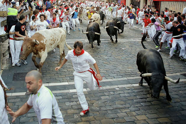 Revellers run with Dolores Aguirre's ranch fighting bulls at Curva Estafeta during the third day of the San Fermin Running Of The Bulls festival, on July 8, 2013 in Pamplona, Spain. The annual Fiesta de San Fermin, made famous by the 1926 novel of US writer Ernest Hemmingway 'The Sun Also Rises', involves the running of the bulls through the historic heart of Pamplona for nine days from July 6-14. Photo: Pablo Blazquez Dominguez, Getty Images / 2013 Getty Images