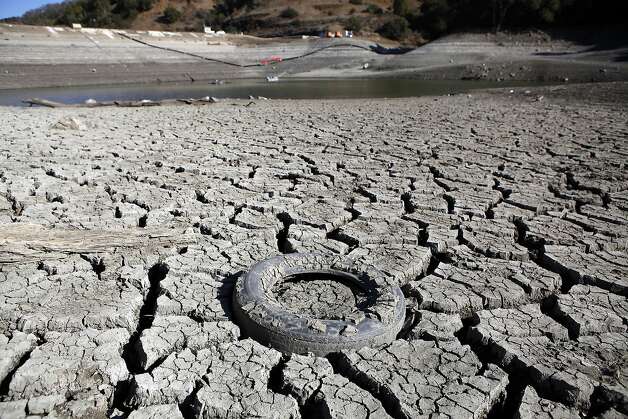 A discarded tire is seen stuck in the exposed lake bed of the Almaden Reservoir which is experiencing extremely low water levels due to the ongoing drought, in San Jose. Photo: Michael Short, The Chronicle