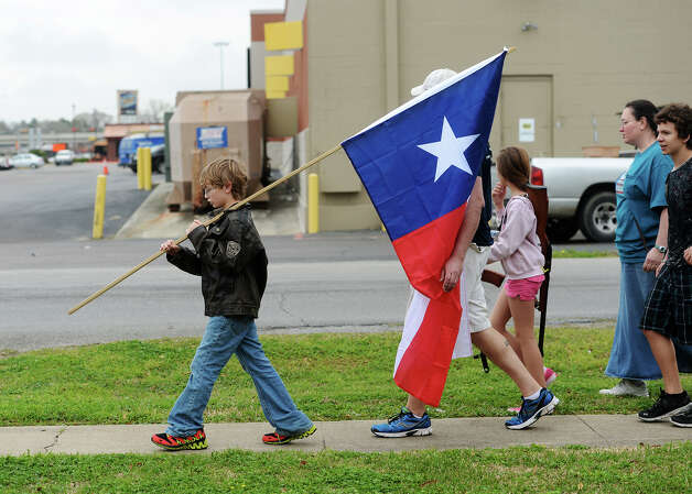 Ryley Franklin, 13, carries a Texas state flag during Saturday's rally. Come and Take It Beaumont held a march down Dowlen Road on Saturday. The participants carried long arms as well as Texas and United States flags from Sertinos Cafe to Lowes.
Photo taken Saturday, 3/15/14
Jake Daniels/@JakeD_in_SETX Photo: Jake Daniels / ©2014 The Beaumont Enterprise/Jake Daniels