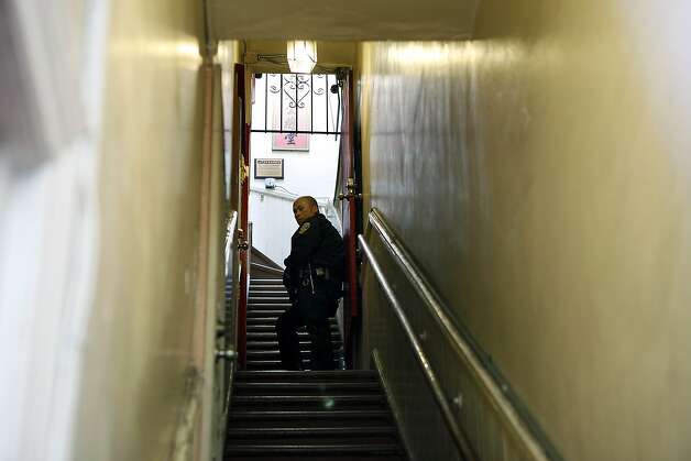 An SFPD officer guards the stairwell of the Ghee Kung Tong Chinese Free Masons Temple in Chinatown during a raid related to Sen. Leland Yee's arrest, San Francisco, CA, Wednesday Mar. 26, 2014.  The FBI raids State Sen. Leland Yee's office in Sacramento and other locations were searched by the FBI in San Francisco. He was reportedly arrested on public corruption charges Wednesday morning amid raids of his office in Sacramento and searches by the FBI in San Francisco. Photo: Michael Short, The Chronicle