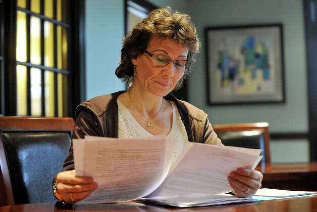 Kristen Rich, a former assistant clerk in the Stamford Probate Court, looks over paperwork while answering questions from a reporter at her home in Stamford, Conn., on Tuesday, April 15, 2014. Rich claims she was fired for trying to organize a union after testifying at a public hearing in Hartford on proposed legislation that would allow probate workes to unionize. She has since filed a labor board complaint against probate for her termination. Photo: Jason Rearick / Stamford Advocate