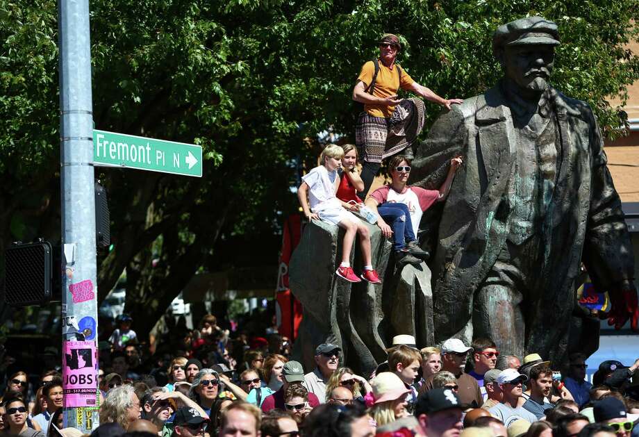 Spectators watch from Fremont's Lenin statue during the annual Fremont Solstice Parade on Saturday, June 21, 2014. Photo: JOSHUA TRUJILLO, SEATTLEPI.COM / SEATTLEPI.COM
