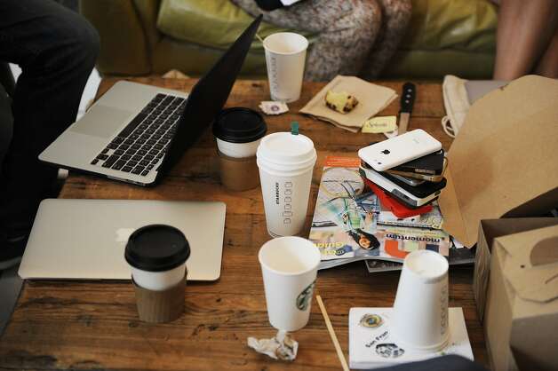 Coffee and phones adorn the table during a meeting for Near Me employees at Makeshift Society in the Hayes Valley area on July 16, 2014 in San Francisco, CA. Near Me is a startup company with a "just add water" platform for companies that want to be the "Airbnb of X." Once a month, for a change of scenery, Near Me rents a bigger office space. Photo: Craig Hudson, The Chronicle
