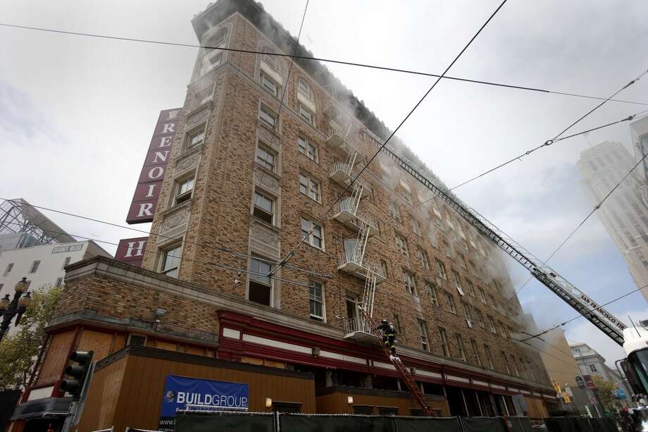 Smoke could be seen coming from the windows of hotel being renovated Monday August 4, 2014. San Francisco firefighters battled a smokey fire at the shuttered Renoir Hotel on McAllister Street. Fire crews closed Market Street and adjoining avenues pouring water into the hotel. Photo: Brant Ward, San Francisco Chronicle