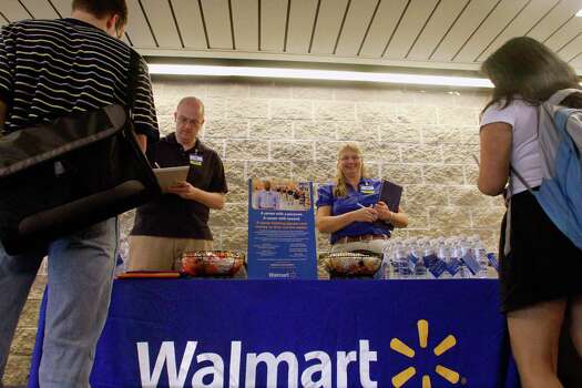 In this file photo, Wal-Mart employees Jon Christians and Lori Harris ...