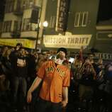 A man waits for touch down after tossing a burning effigy of a Royals players into the air near the intersection of 19th and Mission Street on Wednesday, October 29, 2014.