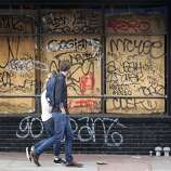 Pedestrians walk past a graffiti covered storefront on Mission Street in San Francisco, Calif. on Thursday, Oct. 30, 2014 after the Giants beat the Kansas City Royals in the World Series. The celebration turned ugly when crowds became unruly and vandalized several businesses and vehicles.