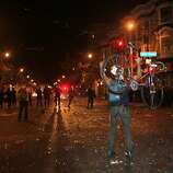 David Archard, of Oakland, holds his bike up and yells at the riot police, who have formaed a line at the intersection, after the Giants won game 7 of the World Series in the Mission of San Francisco, Calif., on Wednesday October 29, 2014.