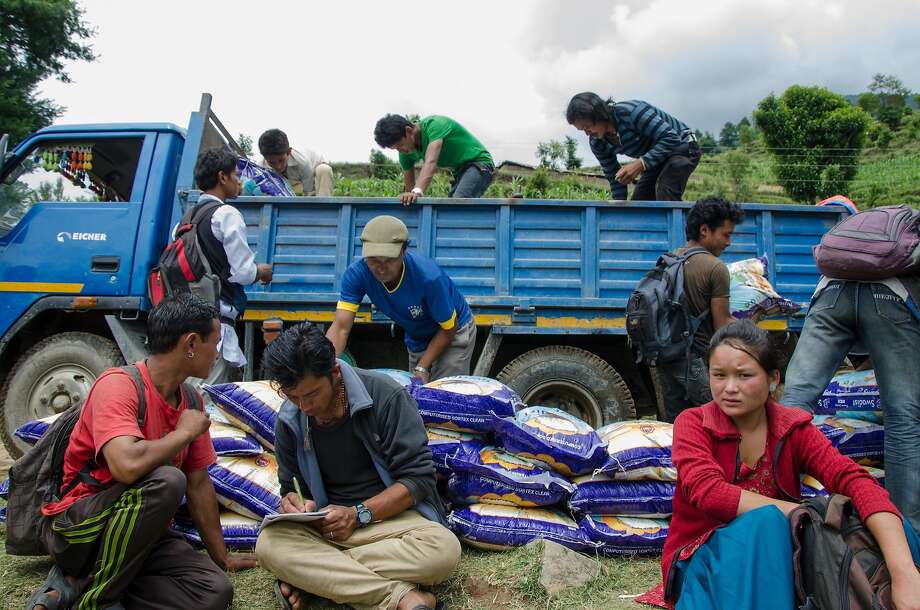 Villagers unload the supply truck from Kathmandu at the end of the road in Bothang. The truck contains two months worth of supplies for 187 families. Photo: Nat Needham, Special To The Chronicle