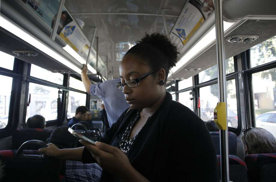 Sarah Glover Johnson of Oakland uses AC Transit’s free Wi-Fi service on her smartphone aboard a bus from Oakland to S.F. Photo: Michael Macor, The Chronicle