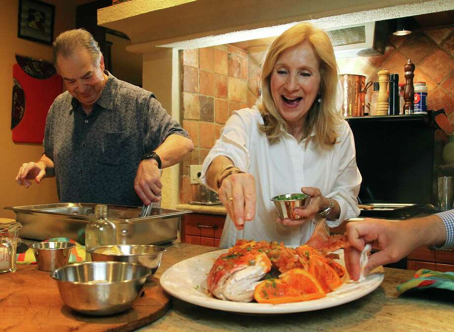 Jim and Diane Gossen put the finishing touches on a whole snapper in their home kitchen. Photo: Mark Mulligan, Staff / © 2015 Houston Chronicle