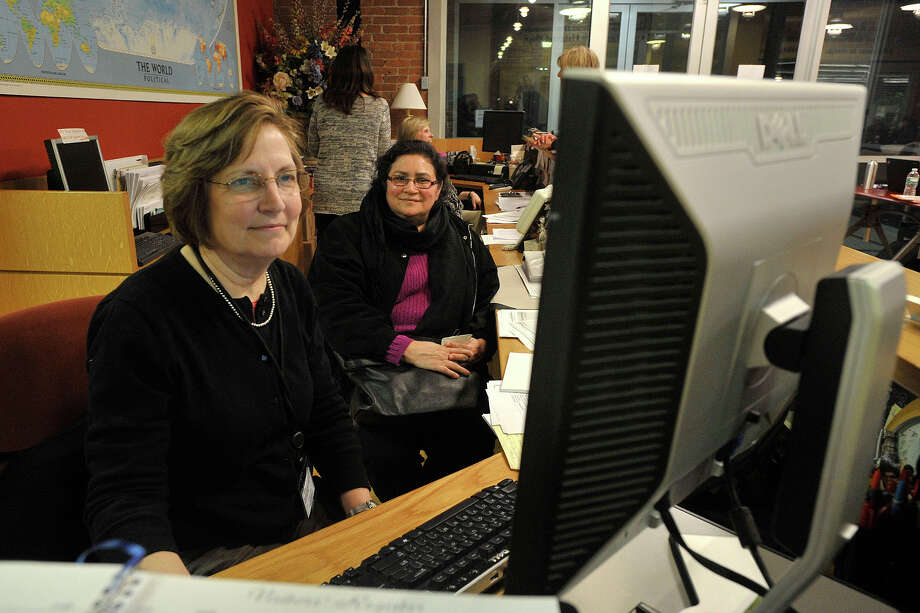 Lorraine Larkin, left, helped Piedad España sign up for Access Health CT at an AmeriCares clinic in Stamford, Conn., during the 2014 open enrollment period. Anthem BlueCross BlueShield remains the market leader with some 1.1 million members in Connecticut. Photo: Jason Rearick / Jason Rearick / Stamford Advocate