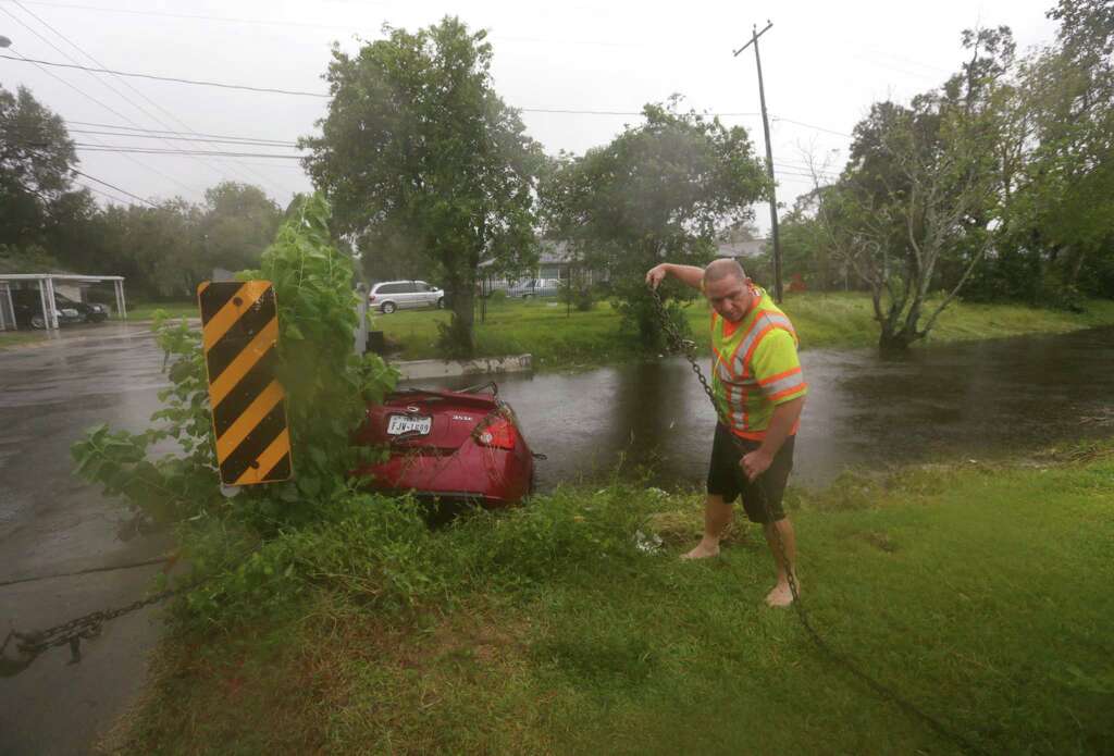 John Thomason, a tow truck driver from Cleveland, Texas, works to get a car out of a bayou near Doulton Drive and Southbank Sunday, Oct. 25, 2015, in Houston. Firefighters arrived and searched the vehicle, but they did not find anybody in or around the car, according to police. Heavy rains moved into the area over night dropping four to nine inches of rain across parts of Harris County. Photo: Jon Shapley, Houston Chronicle / © 2015  Houston Chronicle