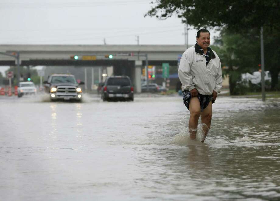 Eleazar Sanchez wades through high water on Fondren Road near the Southwest Freeway to test its depth before driving through it Sunday, Oct. 25, 2015, in Houston. Heavy rains moved into the area over night dropping four to nine inches of rain across parts of Harris County. Photo: Jon Shapley, Houston Chronicle / © 2015  Houston Chronicle