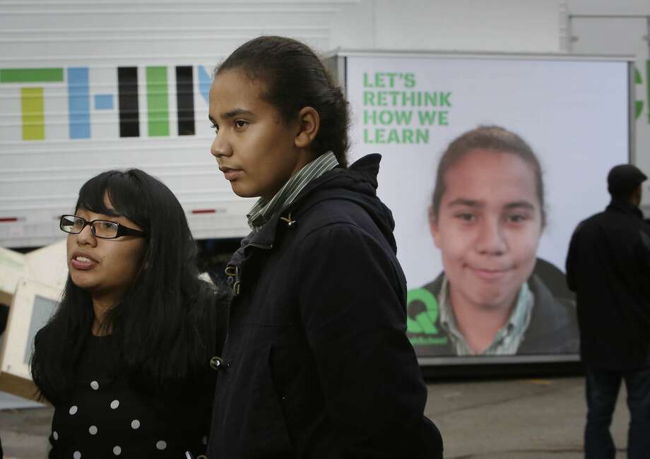 Maya Martin (l to r), 16, junior West High School, Aaron Jackson, 15, sophomore West High School stand together as they are interviewed for a promotional video at the XQ roadshow while Jackson's image is displayed on the XQ We Think booth behind her on Wednesday, December 9,  2015 in Oakland, Calif. Photo: Lea Suzuki, The Chronicle