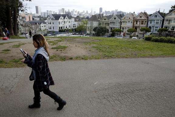 Diana Hoang takes a tour of the Western Addition neighborhood near the Painted Ladies using the Detour application in San Francisco, California, on Wednesday, March 31, 2016.