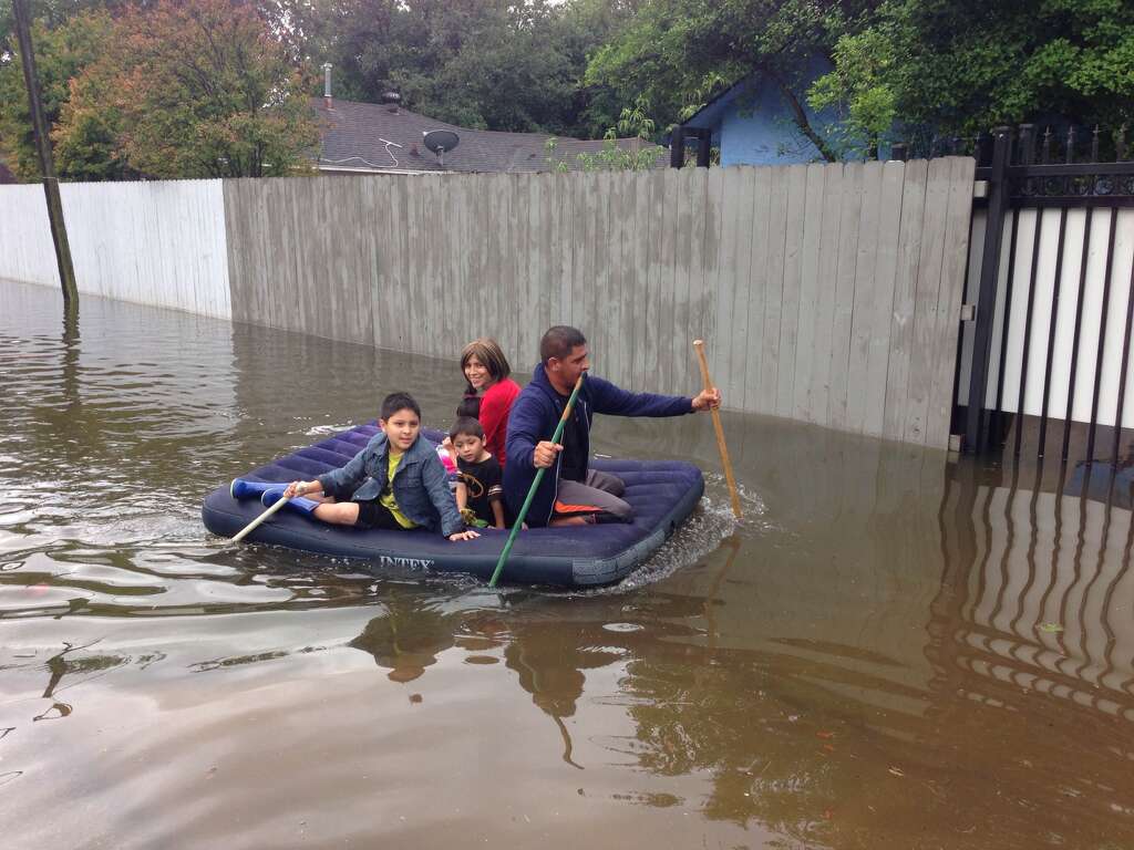 A family of five floats past on an inflated air mattress in an Aldine-area neighborhood. On board were Jesus Amador, Fabiola Medina and three children, ages 7, 4 and 2.  Photo: Rebecca Elliott/Houston Chronicle