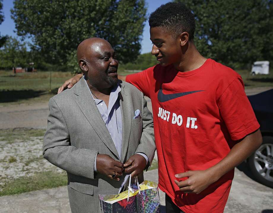 Dwight Beal,14, hugs Rev. Joey Crutcher whose son Terence Crutcher was shot and killed by Tulsa Police Friday night Sept. 17, 2016. Joey Crutcher attended an event that he helped organize called Men's Encounter. The event was held to mentor  African American men and help them become successful. It also taught how do interact with police if they were to come in contact with them. Beal, who attends church with Crutcher, wanted to check on him becuase his son had been shot and killed by Tulsa Police the night before. (Mike Simons/Tulsa World via AP) Photo: Mike Simons, Associated Press