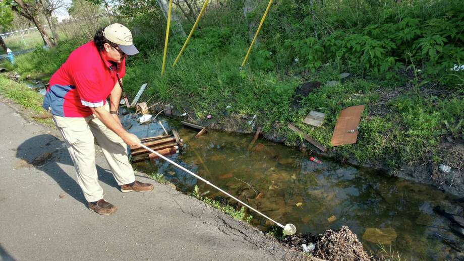 Salvador Rico, inspection supervisor with Harris County's ﻿Mosquito Control Division, examines standing water in a roadside ditch near SH-288 and Old Spanish Trail for larva, which can grow up to transmit disease. ﻿ Photo: Mihir Zavari / Houston Chronicle