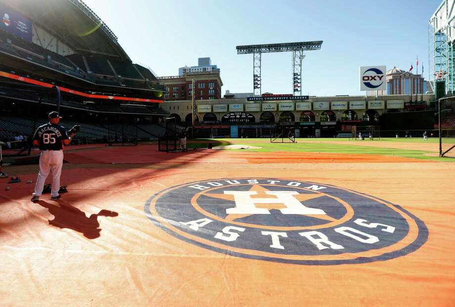 Houston Astros bullpen catcher Javier Bracamonte casts a shadow on the ground covering on the field during batting practice before the start of an MLB exhibition game at Minute Maid Park, Thursday, March 30, 2017, in Houston.  ( Karen Warren / Houston Chronicle ) Photo: Karen Warren, Staff Photographer / 2017 Houston Chronicle