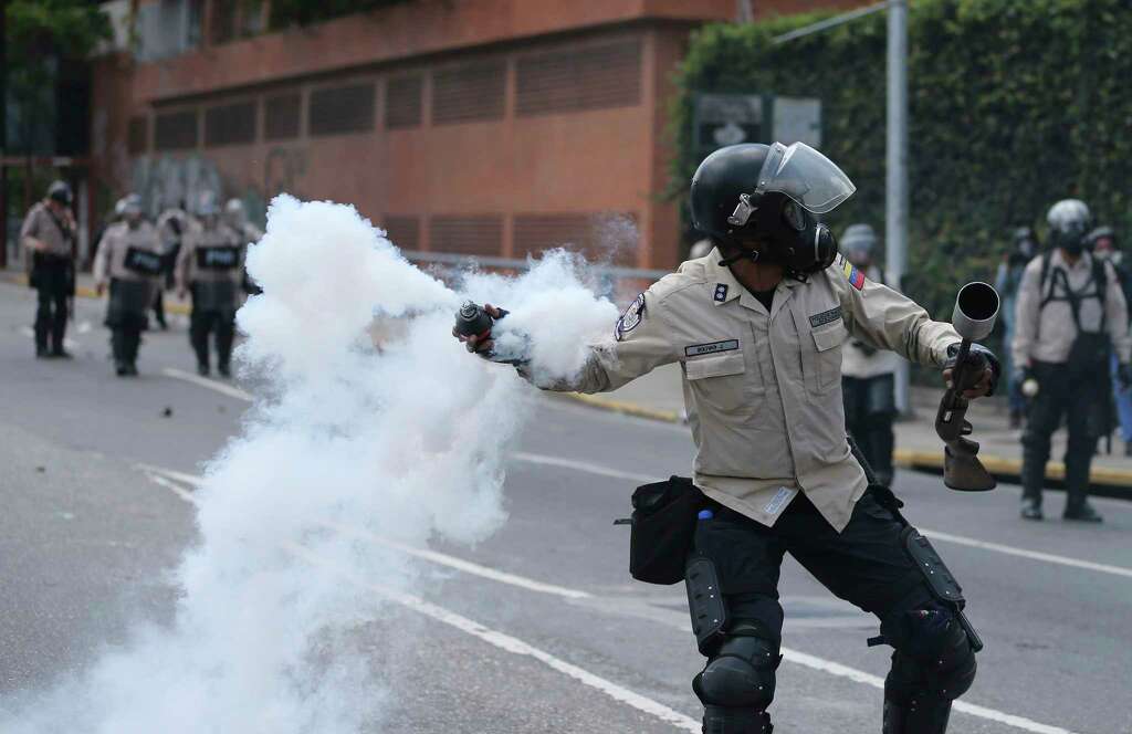 A Bolivarian National Police officer throws a tear gas bomb toward demonstrators during a protest in Caracas, Venezuela, Saturday. Photo: Fernando LLano, STF / Copyright 2017 The Associated Press. All rights reserved.