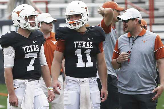 Quarterbacks Shane Buechele (7) and Sam Ehlinger (11) share a laugh with coach Tom Herman as the Texas Longhorns play their spring game on April 15, 2017, in Austin.