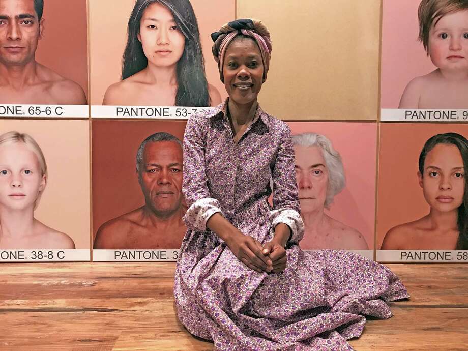 Angelica Dass, a Brazilian artist who lives in Spain, poses at the entrance to her exhibition "Humanae," on view at the Health Museum through Sept. 5. Photo: Molly Glentzer, Houston Chronicle