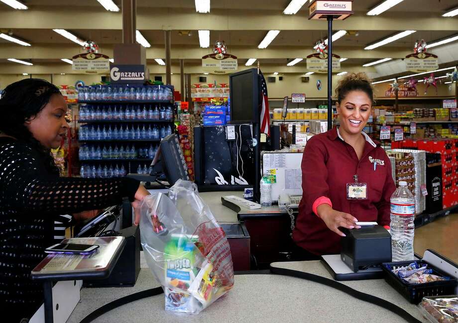 Faye Algazzali (right), an owner of Gazzali’s Supermarket in East Oakland, rings up purchases for customer Jonell Walker. Photo: Leah Millis, The Chronicle