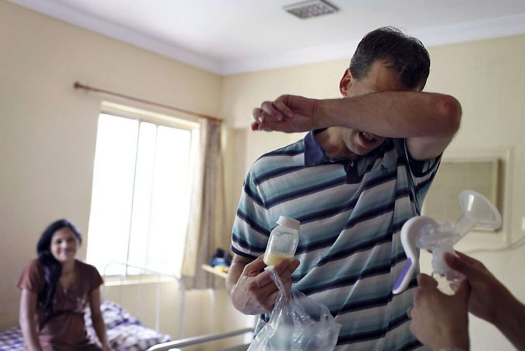 Overcome by extreme heat and gratitude, Steve Kowalski receives the first batch of breast milk from surrogate Manisha Parmar at the Akanksha Infertility Clinic, Sunday, May 26, 2013, in Anand, India. Photo: Nicole Fruge, The Chronicle