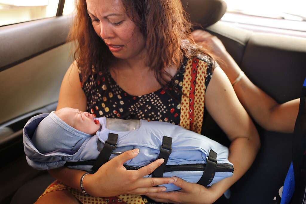 Jennifer Benito-Kowalski holds her son baby Kyle Benito Kowalski for the first extended time in a car outside the Akanksha Infertility Clinic in Anand, India, Thursday, May 23, 2013. The car travelled two blocks to the Apara Nursing Home, a hospital whose facilities included a neonatal intensive care unit. The Kowalskis had no idea where the baby was being taken until they arrived. Photo: Nicole Fruge, The Chronicle