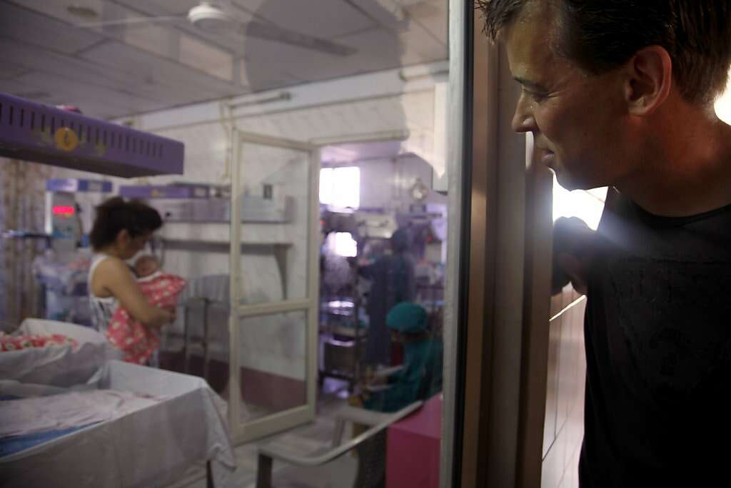Steve Kowalski watches his with Jennifer Benito-Kowalski holds their son Kyle Benito Kowalski in the nursery at the Apara Nursing Home in Anand, India, Friday, May 24, 2013. Photo: Nicole Fruge, The Chronicle