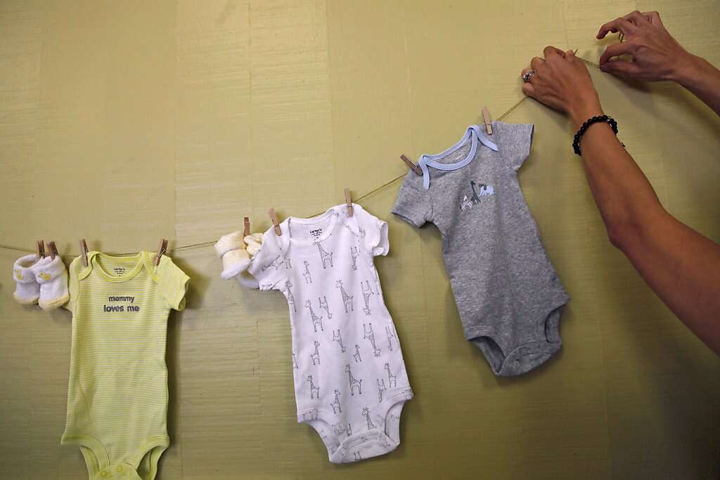 Cindy Vitales, a childhood friend of Jennifer Benito-Kowalski's, hangs decorations before Steve and Jennifer's baby shower at the Fairbrae Swim and Racquet Club in Sunnyvale, Calif., on Saturday, April 6, 2013. After years of trying to conceive, the Kowalskis paid a surrogate in India to carry their child. Photo: Nicole Fruge, The Chronicle