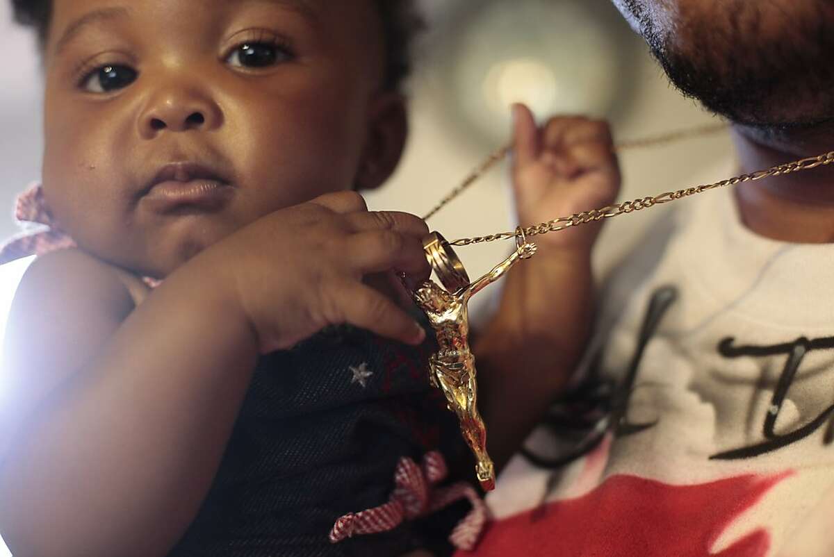 Ramon Price Sr. holds his grandchild KaMya Price, the daughter of his son Lamont Price,  Wednesday July 4, 2012, in Oakland, Calif. KaMya was just weeks old when her father, Lamont was killed, February 16th  in Oakland. Photo: Lacy Atkins, The Chronicle