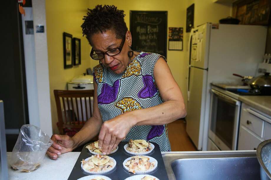 Renée McGhee sprinkles brown sugar on bread pudding as she bakes in her kitchen in Berkeley. She works with Josephine. Photo: Gabrielle Lurie, Special To The Chronicle