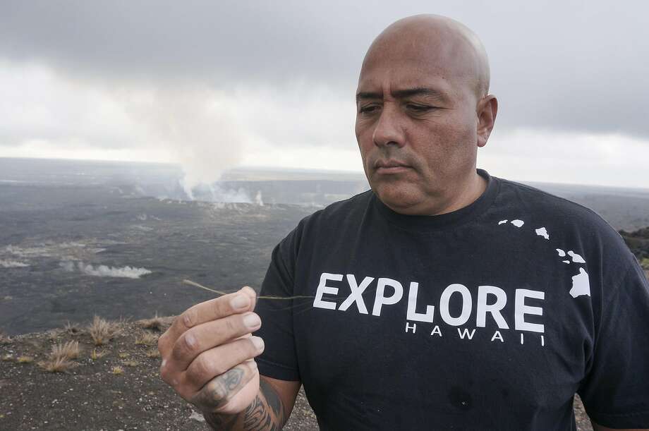 Warren Costa of Local Guide Hawaii displays a thread of golden glass: “Pele’s hair,” formed when ejected globs of lava pull apart. Photo: Jeff Greenwald, Special To The Chronicle