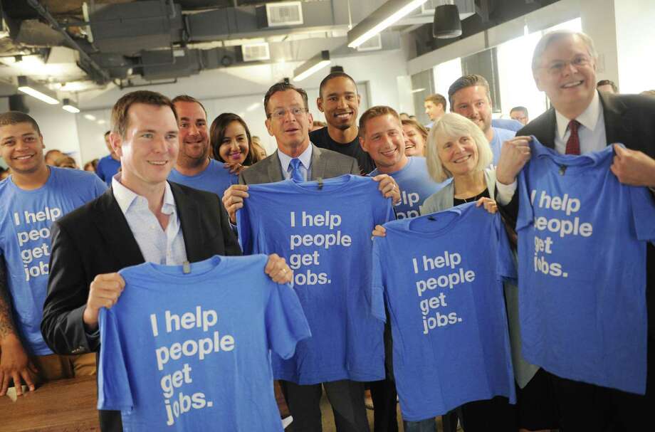 Front row, from left, Indeed SVP and CFO Dave O'Neill, Connecticut Gov. Dannel P. Malloy, Connecticut Department of Economic and Community Development Commissioner Catherine Smith, and Stamford mayor David Martin hold up company T-shirts with employees after speaking at the Indeed headquarters in Stamford, Conn. Wednesday, July 12, 2017. Online job-search giant Indeed plans to create up to 500 new jobs over the next few years through tens of millions of dollars in company investment and state aid, Gov. Dannel P. Malloy and company executives announced Wednesday. Photo: Tyler Sizemore / Hearst Connecticut Media / Greenwich Time